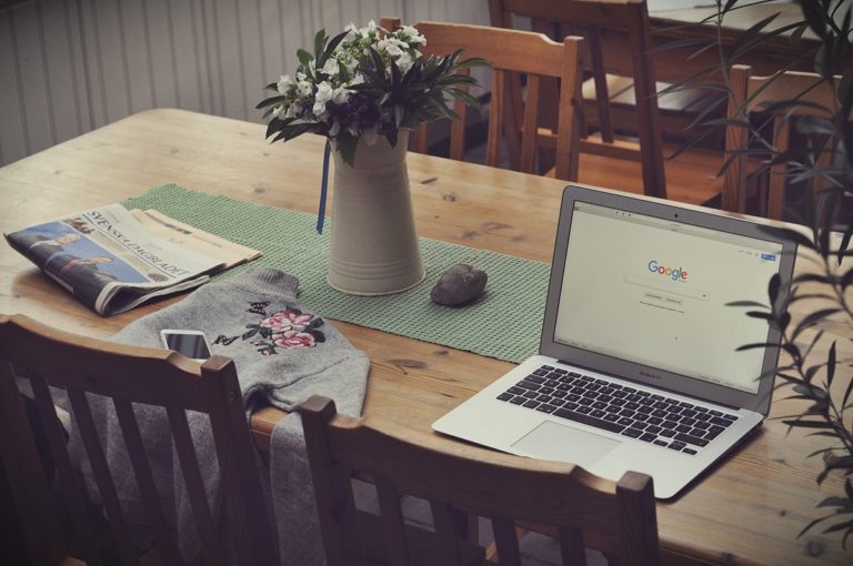 Laptop on a table with Google's homepage on it